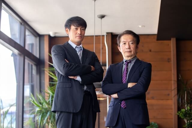 オフィスで腕を組む二人のビジネスマン